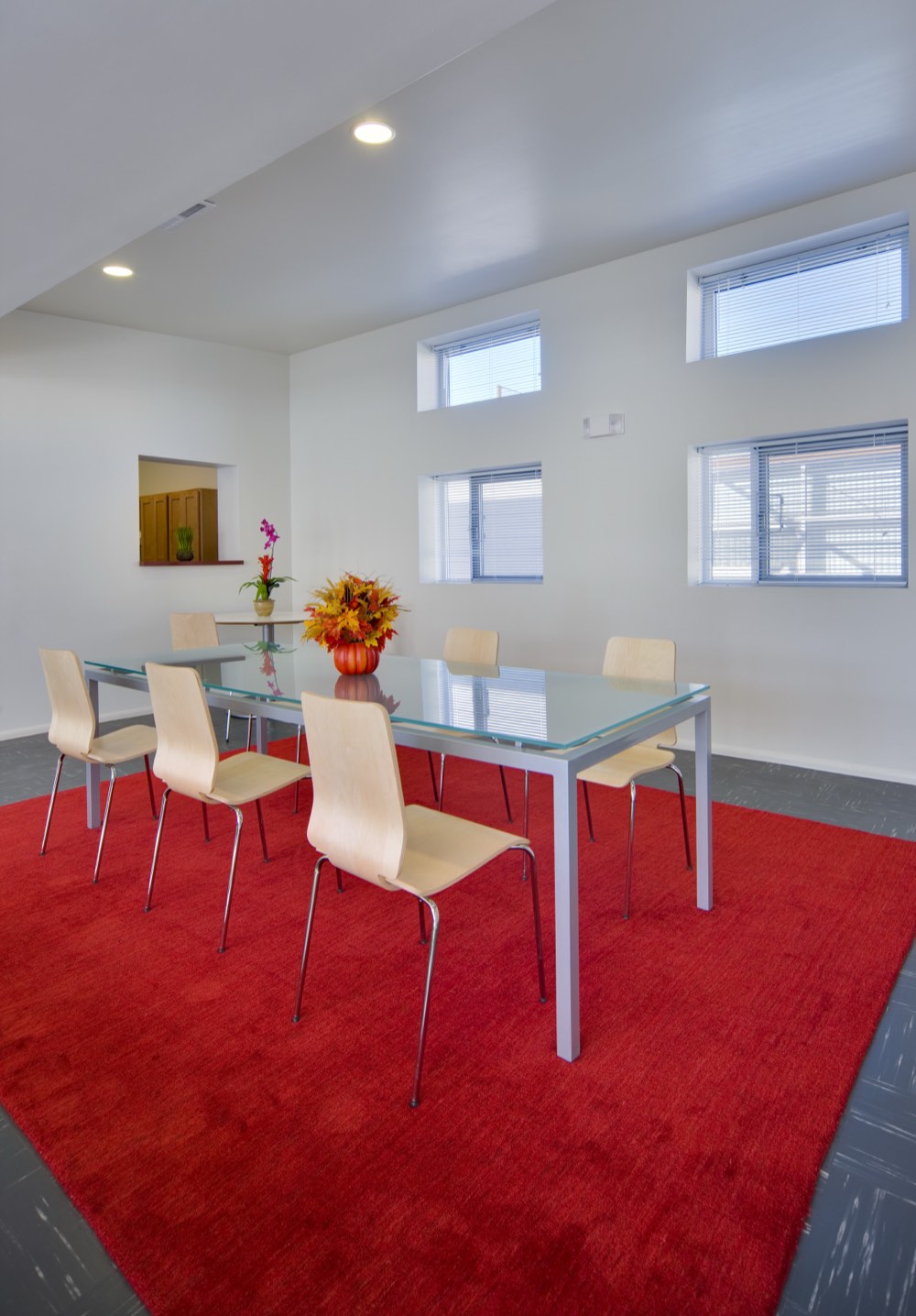 Community center dining and meeting room at Lo Lomas with a glass table and bright windows