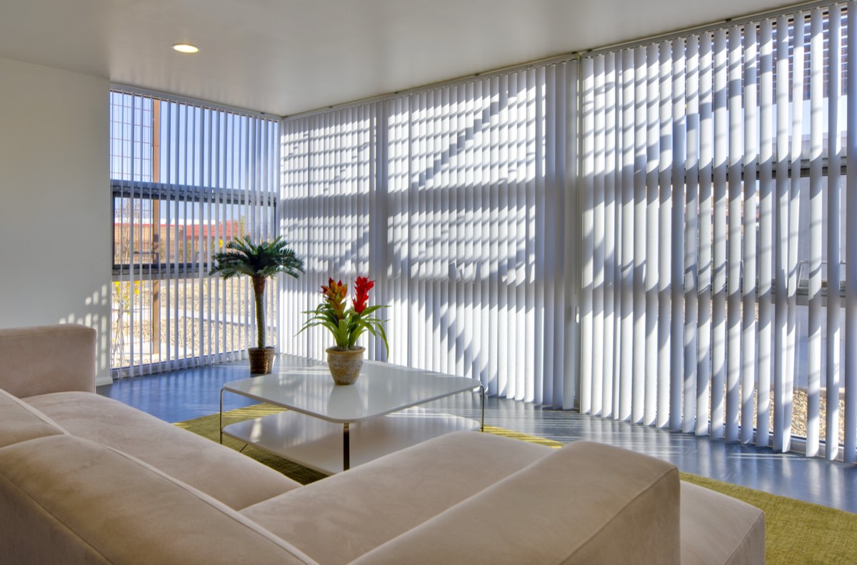 Community center sitting area at Lo Lomas with flowers on the coffee table and filtered light through vertical blinds