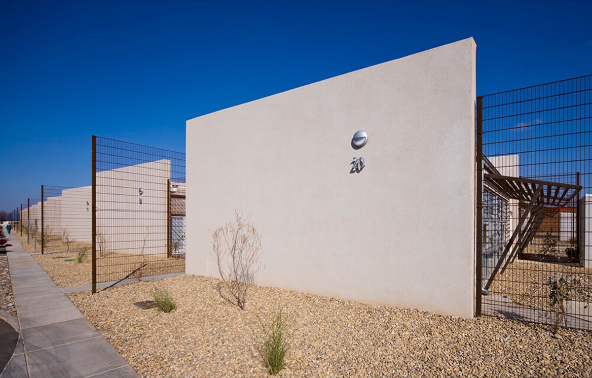 Single-story stucco apartment homes with gravel yards and privacy fencing at Lolomas, Clovis NM